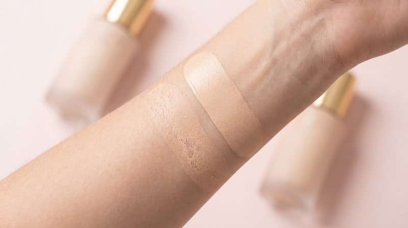Thumbnail for Shade Ladder: two foundation swatches side by side on a forearm against a pale blush background, the left one patchy and the right one smooth. No text on the image.